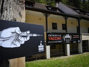 A banner reading in Romanian "Who's afraid of vaccine" and depicting syringes as vampire fangs advertises the vaccination marathon organised at the "Bran Castle" in Bran village on May 8, 2021. Romanian authorities organise during a whole weekend a non-stop vaccination marathon in several locations and Bucharest to offer to the people the opportunity to get vaccinated without prior appointment, hoping to increase the appetite of the population for the vaccines against Covid-19
