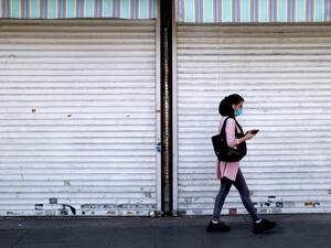 An Iranian woman wearing a protective mask due to the COVID-19 pandemic walks past a shuttered shop in Enghelab suqare in the centre of Iran's capital Tehran on May 16, 2021. Iranian newspapers voiced concern about the potential turnout for next month's presidential poll, a day after candidate registration ended with several heavyweights joining the race.