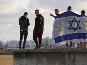 Israelis gather to watch the Iron Dome aerial defence system launch a missile to intercept a rocket launched from the Gaza Strip, above the southern Israeli city of Ashdod