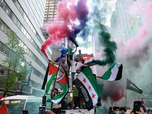 Demonstrators hold Palestine and Syrian flags in support of Palestine in midtown Manhattan, New York City