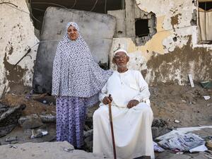 Palestinian Mahmoud Abu Shamala and his wife Raja pose for a photo by their destroyed home in Gaza City on May 27, 2021, in the aftermath of the conflict between Israel and the Gaza-based Hamas movement