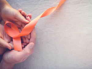 Adult and child hands holding orange Ribbons, Leukemia cancer awareness and Multiple sclerosis awareness