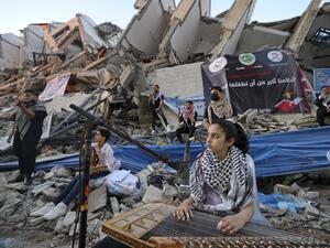 Palestinian musicians perform on the rubble of the Hanadi Tower during an event organised by the Palestinian Committee on Youth and Culture in Gaza City on June 2, 2021, more than a week after a ceasefire brought an end to 11 days of hostilities between Israel and Gaza rulers Hamas
