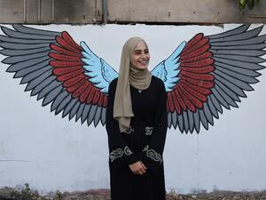 Palestinian activist Mona el-Kurd, 23, talks to well wishers upon arrival at home in the neighbourhood of Sheikh Jarrah in Israeli-annexed east Jerusalem after being released from an Israeli police station