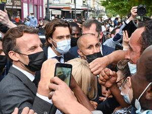 French President Emmanuel Macron interacts with members of a crowd while visiting Valence on June 8, 2021 during a visit in the French southeastern department of Drôme, the second stage of a nationwide tour ahead of next year's presidential election. PHILIPPE DESMAZES / POOL / AFP French President Macron slapped in face by member of public