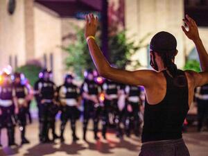 A protester puts his hands up in front of a line of police in riot gear in the US city of Columbus, Ohio, on June 5, 2020.  © 2020 Stephen Zenner / SOPA Images/Sipa USA via AP Images International Probe of Police Violence Urgently Needed