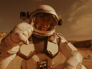 Male astronaut recording video on Mars