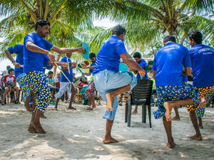 Kalpeni, Lakshadweep, Men performing traditional local dance on tropical island beach