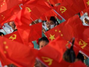 Students wave flags of China and the Communist Party of China before celebrations in Beijing on July 1, 2021, to mark the 100th anniversary of the founding of the Communist Party of China. 