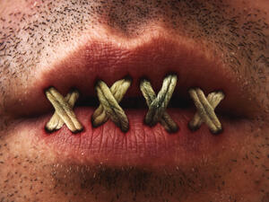 Close up of mans mouth with lips stitched or sewn shut