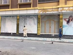 Taliban militants cover models' faces in Kabul streets
