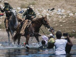 US Customs and Border Protection agents on horseback deployed against Haitian migrants as they cross the Rio Grande from Ciudad Acuña, Mexico, into Del Rio, Texas, September 19, 2021. © 2021 AP Photo/Felix Marquez Chased by Border Agents on Horseback; Returned to Danger in Haiti