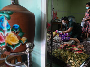 volunteer (C) treating a patient with Covid-19 coronavirus at their home in Taungoo district in Myanmar's Bago region some 220km from Yangon. (Photo by Ye Aung Thu / AFP) Warn Violators They Will Be Held to Account