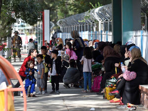 A Taliban Badri fighter, a "special forces" unit, stands guard as Afghans hoping to leave Afghanistan wait at the main entrance gate of Kabul airport in Kabul on August 28, 2021, following the Taliban stunning military takeover of Afghanistan. (Photo by WAKIL KOHSAR / AFP) Rising Hunger; Collapsing Education, Health Systems