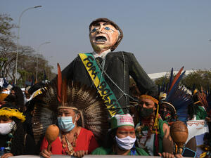 Indigenous female protesters carry an effigy of Brazilian President Jair Bolsonaro during a demonstration to exert pressure ahead of a crucial Supreme Court ruling that could take away their ancestral lands, in Brasilia on September 10, 2021. (Photo by Carl DE SOUZA / AFP) Harasses Supreme Court, Signals He May Cancel Elections, Violates Free Speech