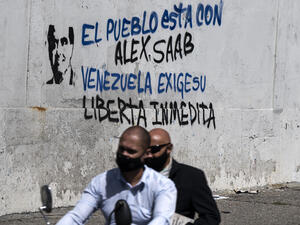 Two men ride on a motorcycle past a graffiti reading "The People is with Alex Saab ... Venezuela Demands his Immediate Release" in Caracas on September 10, 2021, (Photo by Yuri CORTEZ / AFP) The extradition of Venezuelan diplomat Alex Saab to the US from Cape Verde is one of the causes for diplomatic tensions between President Maduro’s government and Washington.