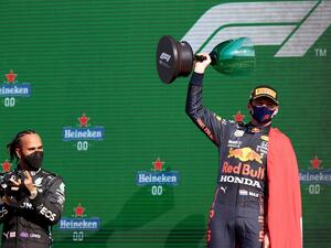 Red Bull's Dutch driver Max Verstappen (R) holds the winner's trophy as Mercedes' British driver Lewis Hamilton (L) applauds on the podium of the Zandvoort circuit after the Netherlands' Formula One Grand Prix in Zandvoort on September 5, 2021. (Photo: AFP)