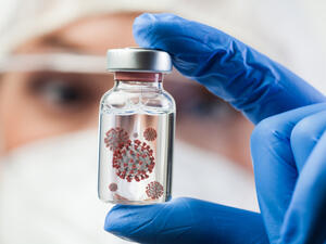 Female UK lab scientist doctor holding glass ampoule vial containing Coronavirus molecule cell