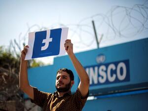 A Palestinian demonstrator holds a banner of the Facebook logo. © 2016 Mohammed Talatene/Anadolu Agency/Getty Images Independent Investigation, Alignment with International Standards Needed