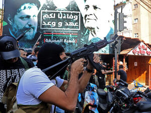 A Hezbollah fighter fires his gun 