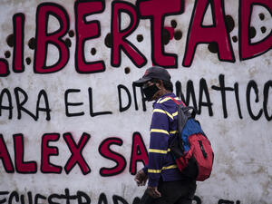 A man walks past a graffiti reading "Freedom for diplomat Alex Saab, kidnapped by the government of Cape Verde" in Caracas, on February 23, 2021. / AFP / Yuri CORTEZ ALEX SAAB’S EXTRADITION IS A SHAMEFUL ACT OF POLITICAL COWARDICE BY CAPE VERDE GOVERNMENT AS LEGAL PROCESS WAS NOT COMPLETE