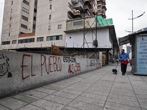 A man walks his dog as he passes a graffiti reading "The people is with Alex Saab" in Caracas, on February 23, 2021. Saab, who is allegedly close to Venezuelan President Nicolas Maduro and wanted in the US for money laundering, has been put under house arrest in Cape Verde. Saab was detained in June 2020 as a plane he was travelling on stopped over in the African country. / AFP / Yuri CORTEZ “The Offices of State are Not Defined by the Person Temporarily Occupying the Seat” – Dr Jose Manuel Pinto Monteiro