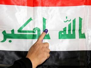Iraqi woman places her finger on the Iraqi flag