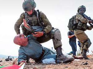 Israeli soldiers hold a Palestinian protester 