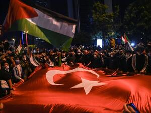 Protesters wave Turkish and Palestinian flags in front of the Israeli consulate in Istanbul