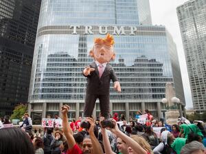 In this file photo taken on October 11, 2015 demonstrators hold up a piñata of Republican Presidential candidate Donald Trump during a protest outside Trump Tower in Chicago, Illinois. SCOTT OLSON / GETTY IMAGES NORTH AMERICA / AFP former president Trump