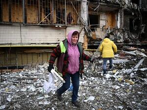 Woman clears items after a residential building in Kiev