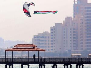 A paraglider flies the Kuwaiti national flag