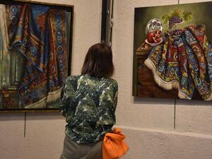 امرأة تركية تعكس نقوش السجاد على لوحات