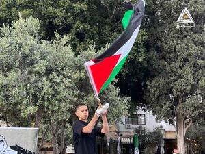 Palestinian boy raises the Palestinian flag