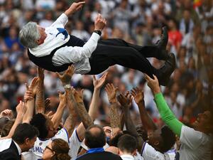 Real Madrid's players carry Real Madrid's Italian coach Carlo Ancelotti at the end of the Spanish League football match between Real Madrid CF and RCD Espanyol at the Santiago Bernabeu stadium in Madrid on April 30, 2022. (Photo by GABRIEL BOUYS / AFP)