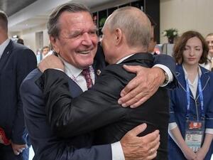 المستشار الألماني السابق، غيرهارد شرودر يعانق الرئيس الروسي بوتين