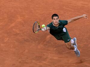 Spain's Carlos Alcaraz returns the ball to Germany's Alexander Zverev during their 2022 ATP Tour Madrid Open tennis tournament men's singles final match at the Caja Magica in Madrid. At just 19, Carlos Alcaraz is bidding to become just the eighth teenager to win a Grand Slam men's singles title at the French Open which gets underway at Roland Garros on May 22, 2022. (Photo by JAVIER SORIANO / AFP)