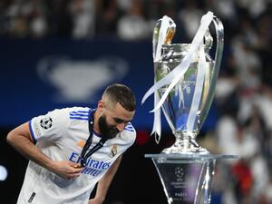 Real Madrid's French forward Karim Benzema walks past the trophy after winning the UEFA Champions League final football match between Liverpool and Real Madrid at the Stade de France in Saint-Denis, north of Paris, on May 28, 2022. (Photo by FRANCK FIFE / AFP)