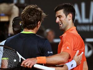 Serbia's Novak Djokovic (R) and Norway's Casper Ruud embrace after Djokovic won their semifinal match at the ATP Rome Open tennis tournament on May 14, 2022 at Foro Italico in Rome. (Photo by Andreas SOLARO / AFP)