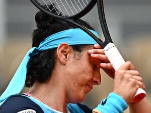 Tunisia's Ons Jabeur reacts as she plays against Poland's Magda Linette during their women's singles match on day one of the Roland-Garros Open tennis tournament at the Court Philippe-Chatrier in Paris on May 22, 2022. (Photo by Anne-Christine POUJOULAT / AFP)