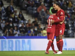 Liverpool's Egyptian forward Mohamed Salah celebrates scoring his team's second goal with Liverpool's Dutch defender Virgil van Dijk during the UEFA Champions League first round group B footbal match between Porto and Liverpool at the Dragao stadium in Porto on September 28, 2021. (Photo by MIGUEL RIOPA / AFP)