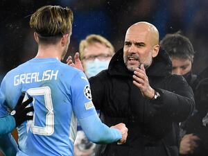 Manchester City's Spanish manager Pep Guardiola (R) speaks with Manchester City's English midfielder Jack Grealish on the pitch after the UEFA Champions League Quarter-final first leg football match between Manchester City and Atletico Madrid at the Etihad Stadium in Manchester, north west England, on April 5, 2022. Manchester City won the game 1-0. (Photo by Oli SCARFF / AFP)