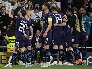 Manchester City players celebrate a goal scored by Manchester City's Algerian midfielder Riyad Mahrez during the UEFA Champions League semi-final second leg football match between Real Madrid CF and Manchester City at the Santiago Bernabeu stadium in Madrid on May 4, 2022. (Photo by JAVIER SORIANO / AFP)