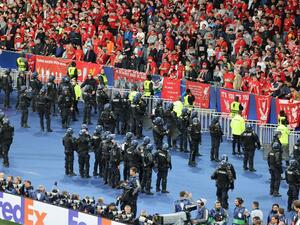 Riot police take up positions in front of the Liverpool fans after the UEFA Champions League final football match between Liverpool and Real Madrid at the Stade de France in Saint-Denis, north of Paris, on May 28, 2022. Real Madrid won the match 0-1. (Photo by Thomas COEX / AFP)