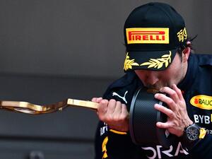 Red Bull Racing's Mexican driver Sergio Perez kisses his trophy on the podium after winning the Monaco Formula 1 Grand Prix at the Monaco street circuit in Monaco, on May 29, 2022. (Photo by SEBASTIEN BOZON / AFP)