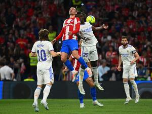 Atletico Madrid's French forward Antoine Griezmann (Top-L) and Real Madrid's French midfielder Eduardo Camavinga (Top-R) jump for the ball during the Spanish League football between Club Atletico de Madrid and Real Madrid CF at the Wanda Metropolitano stadium in Madrid on May 8, 2022. (Photo by GABRIEL BOUYS / AFP)