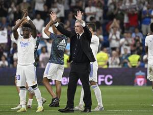 Real Madrid's Italian coach Carlo Ancelotti (C), Real Madrid's Brazilian forward Vinicius Junior (L) and teammates acknowledge the crowd at the end of the Spanish league football match between Real Madrid CF and Real Betis at the Santiago Bernabeu stadium in Madrid on May 20, 2022. (Photo by Pierre-Philippe MARCOU / AFP)