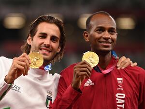 Joint gold medalists Qatar's Mutaz Essa Barshim (R) and Italy's Gianmarco Tamberi pose on the podiumn of the men's high jump final during the Tokyo 2020 Olympic Games at the Olympic Stadium in Tokyo on August 2, 2021. (Photo by Ina FASSBENDER / AFP)