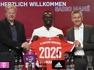 Bayern Munich's Senegalese new forward Sadio Mane (C) with his jersey poses next to Bayern Munich CEO Oliver Kahn (L) and President Herbert Hainer during a press conference after he signed a three-year deal with German first division football club FC Bayern Munich, in Munich, southern Germany, on June 22, 2022. (Photo by CHRISTOF STACHE / AFP)