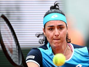 Tunisia's Ons Jabeur plays a forehand return to Poland's Magda Linette during their women's singles match on day one of the Roland-Garros Open tennis tournament at the Court Philippe-Chatrier in Paris on May 22, 2022. (Photo by Anne-Christine POUJOULAT / AFP)